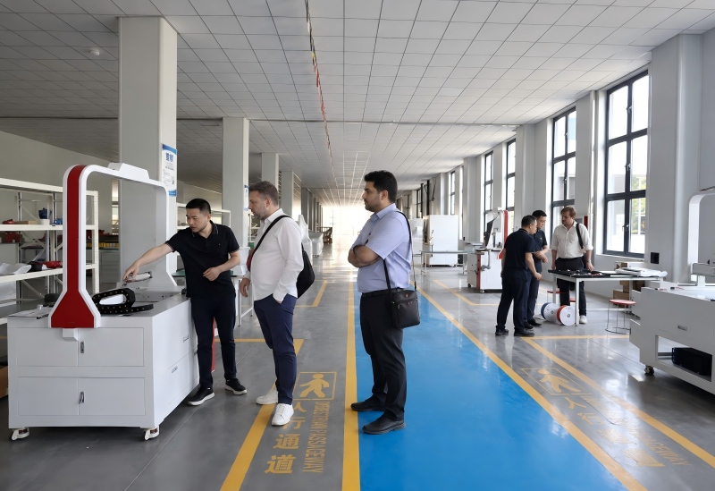 International customers inspecting a laser machine during a SISMAR LASER factory visit
