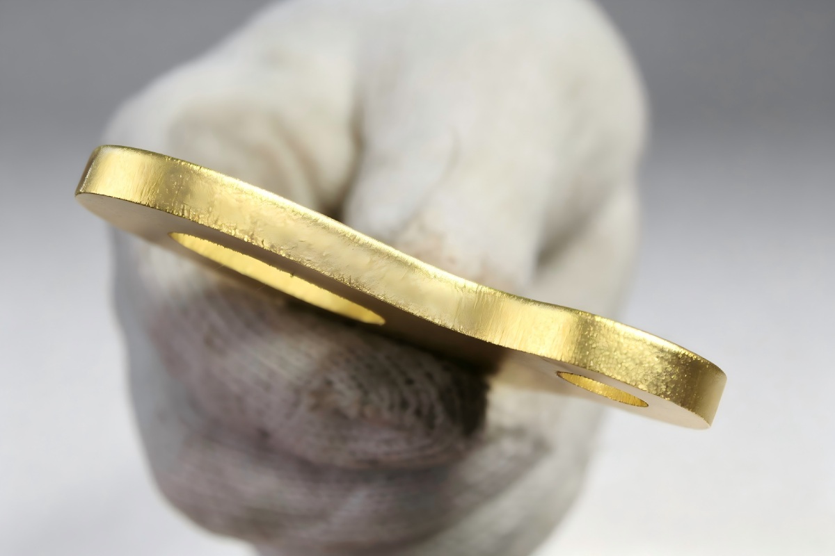 Close-up of a clean laser-cut edge on a pure gold jewelry sample